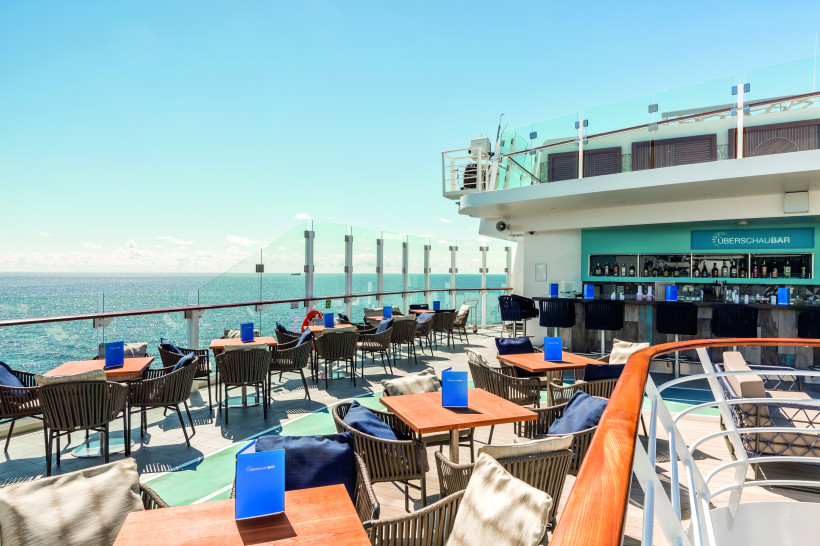 Außenbereich der Überschaubar auf der Mein Schiff 6 mit Sitzplätzen und Blick auf das Meer