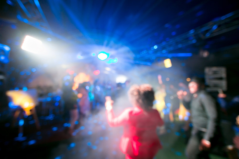 Thailand Pattaya Verschwommene Aufnahme einer bunten Clubszene mit Tanzenden, Lichtstrahlen und Nebel – ausgelassene Partystimmung auf der Tanzfläche.