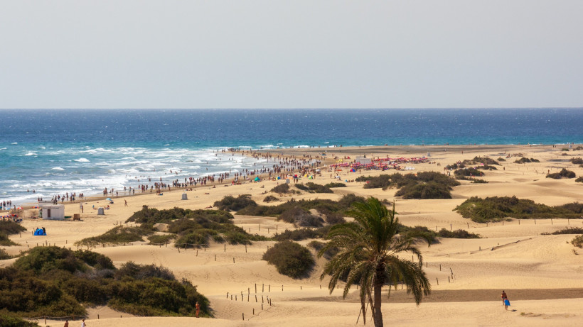 Sanddünen und Strandabschnitt von Playa del Inglés mit Badenden, Sonnenschirmen und Atlantik