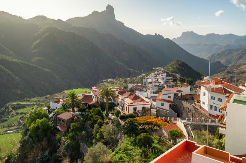 Traditionelles Dorf Tejeda auf Gran Canaria mit weißen Häusern und roten Dächern, umgeben von grünen Tälern und hohen Bergen.