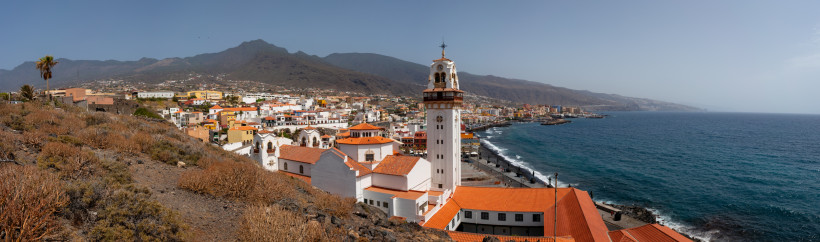 Panoramablick auf Candelaria und die Basilika Nuestra Señora de Candelaria auf Teneriffa Panoramaaufnahme von Candelaria auf Teneriffa mit der Basilika Nuestra Señora de Candelaria im Vordergrund, terrakottafarbenen Dächern, weißer Fassade und Blick auf den Atlantik sowie die Berge im Hintergrund.