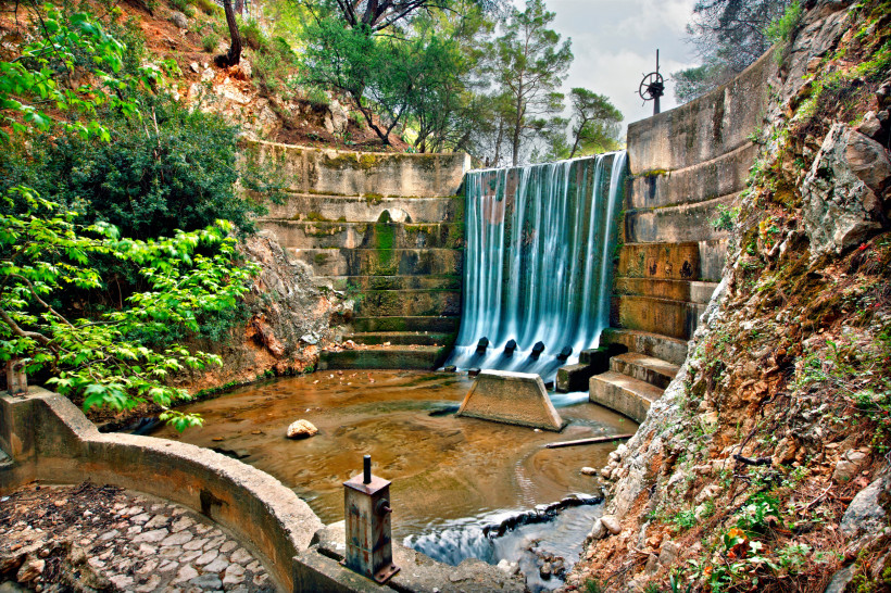Kleiner Wasserfall auf Rhodos mit Staubecken, Felsen und dichter Vegetation – beliebtes Natur- und Ausflugsziel