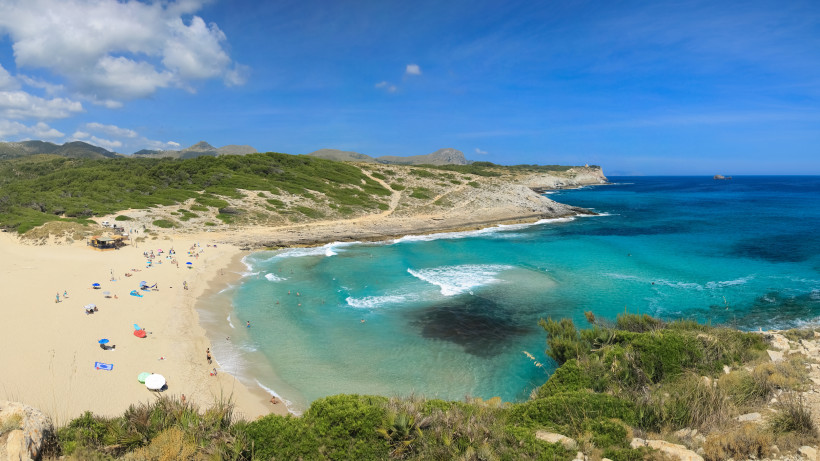 Blick auf die Bucht Cala Torta auf Mallorca mit Sandstrand, türkisfarbenem Meer und felsiger Küste
