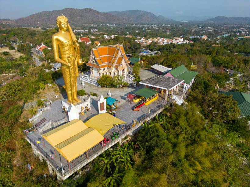 Wat Khao Noi Hua Hin – Goldene Buddha-Statue mit Panoramablick Goldene Buddha-Statue auf dem Wat Khao Noi in Hua Hin mit Tempelanlage und Blick über die hügelige Landschaft des Golfes von Thailand