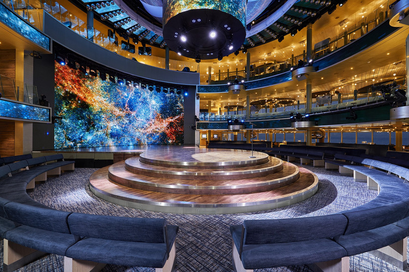 Theatrium der AIDAnova mit runder Bühne, Sitzbereichen und großer LED-Wand