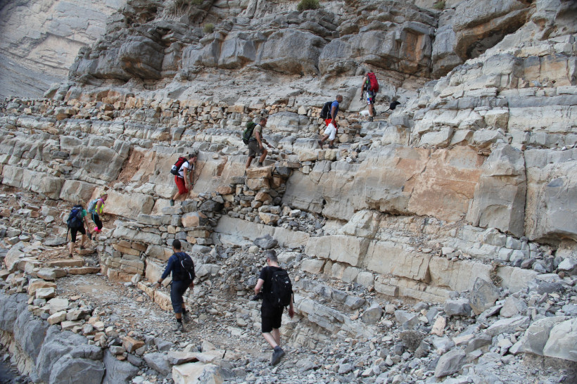 Ras al Khaimah, Aktivurlaub  Gruppe von Wanderern klettert über felsiges Gelände in einer Berglandschaft