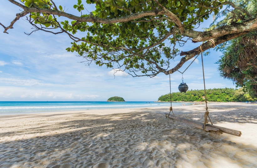 Kata Beach mit Sandstrand, ruhigem Meer und Baumschaukel im Schatten eines Baumes