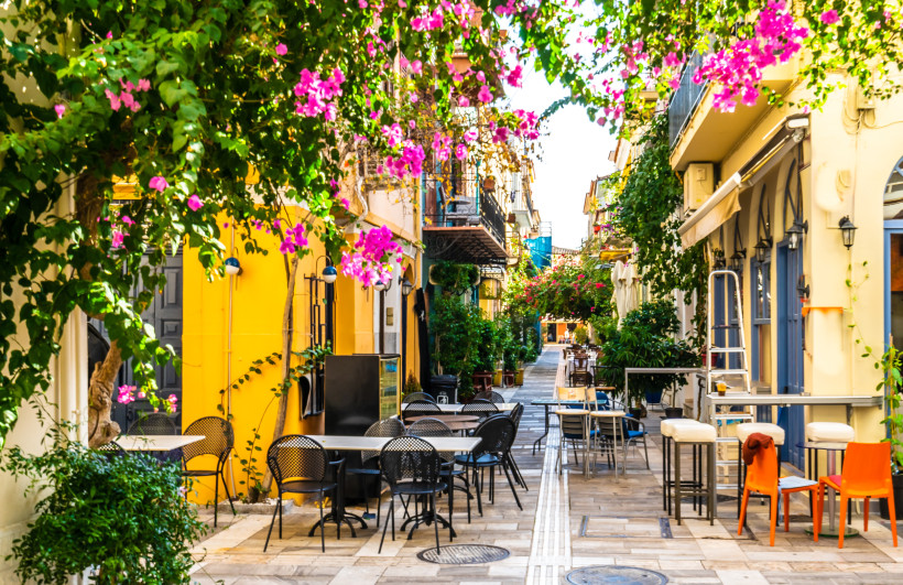Griechenland - Nafplio Romantische Gasse in Nafplio mit bunten Häusern, Blumenranken und gemütlichen Straßencafés