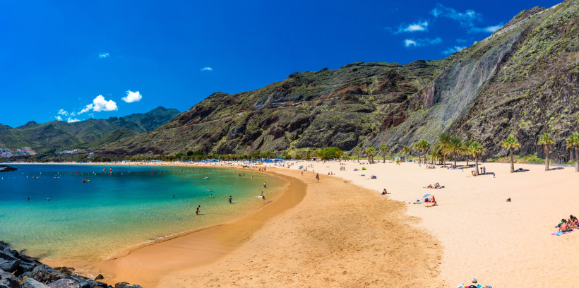 Goldener Sandstrand Playa de Las Teresitas auf Teneriffa mit türkisfarbenem Meer und grünen Bergen im Hintergrund