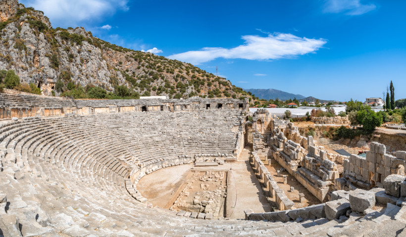 Antikes Amphitheater in der Region Göynük nahe Kemer mit gut erhaltenen Steinrängen, Ruinen und Felslandschaft unter blauem Himmel