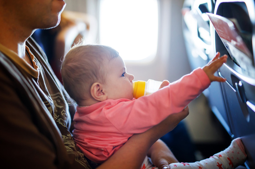 Baby mit Flasche im Flieger