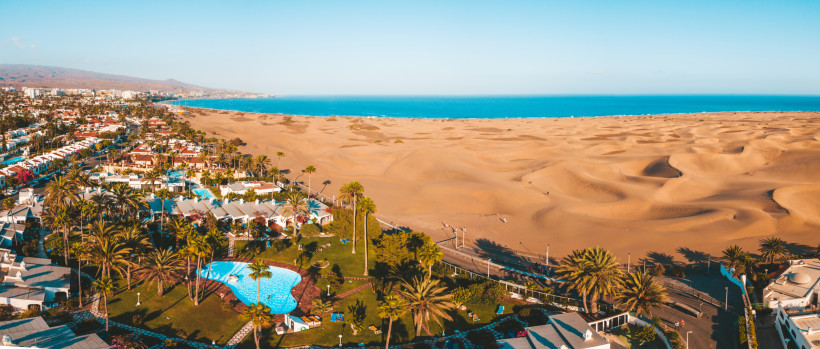 Blick über die Dünen von Maspalomas mit Atlantik und Hotelanlage im Vordergrund