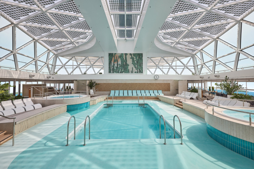 Innenpoolbereich auf der Mein Schiff 7 mit großem Pool, Liegen und Glasdach