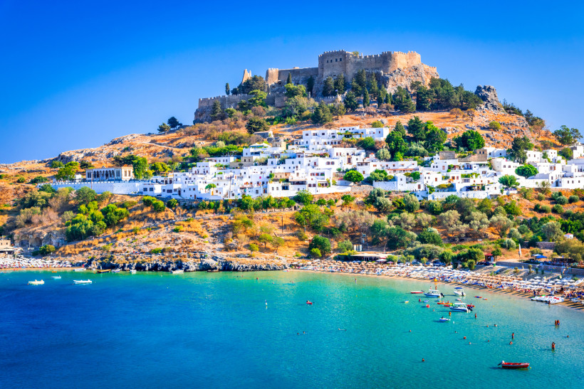 Lindos, Akropolis auf Rhodos, Griechenland eine Burg auf einem Berg, weiße Gebäude und ein Strand am Fuße des Berges
