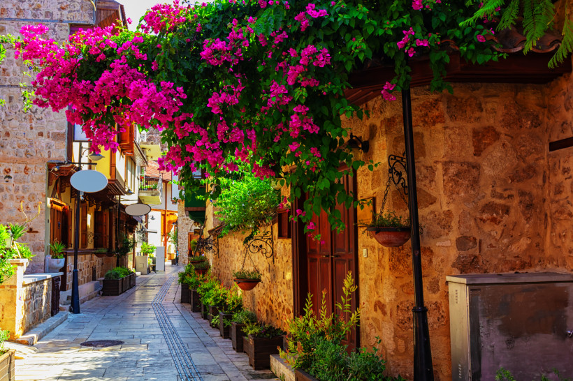 Bunte Bougainvillea in einer historischen Gasse der Altstadt Kaleiçi in Antalya – stimmungsvolle Impressionen für den Antalya Urlaub.