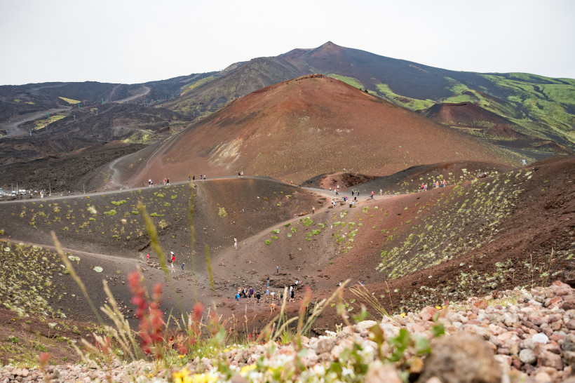 Ätna Wanderung – Kraterlandschaft und Vulkangestein auf Sizilien Wanderer auf den Kraterhügeln des Ätna auf Sizilien – faszinierende Vulkanlandschaft mit Lavagestein, grünen Hängen und beeindruckenden Aussichtspunkten