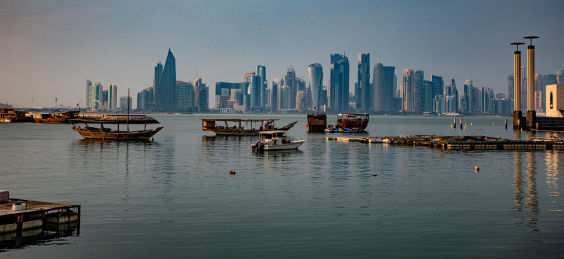 Skyline von Doha am Wasser mit mehreren Booten im Vordergrund