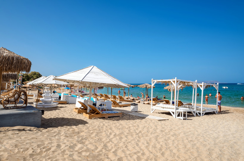 Sandstrand von Analipsi mit Sonnenliegen, Sonnenschirmen und Blick auf das Meer
