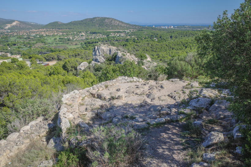 Blick vom Puig de sa Morisca über felsiges Plateau, Pinienwald und Küstenebene