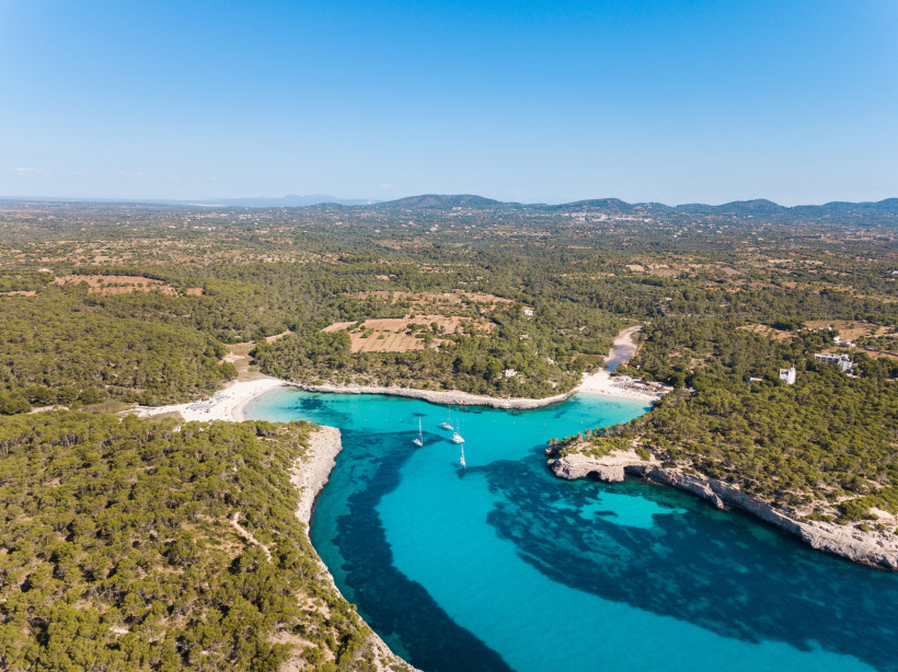Mallorca - Cala Mondrago Luftaufnahme von dem Strand von Cala Mondrago auf Mallorca, türkisblaues Wasser, blauer Himmel und Sonnenschein, üppige Vegetation um die Bucht