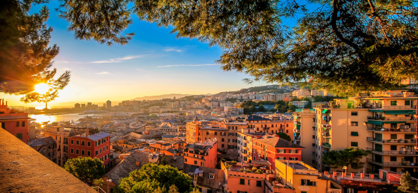 Panoramablick über Genua mit Hafen, Altstadt und farbigen Wohnhäusern im Abendlicht