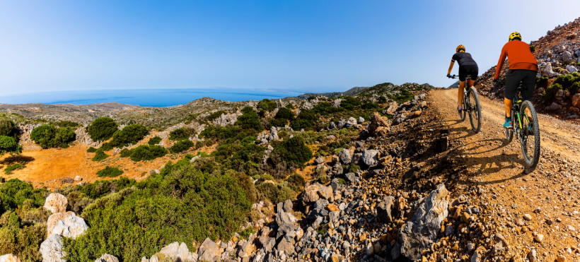 Mountainbiken in der Umgebung von Chersonissos mit Küstenblick Mountainbiker auf Schotterpiste in felsiger Landschaft mit Blick auf das Meer bei Chersonissos
