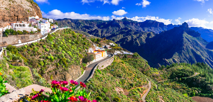 Panoramablick auf die Berglandschaft Gran Canarias Atemberaubende Aussicht auf die kurvenreiche Bergstraße und grüne Hänge im Inselinneren von Gran Canaria.