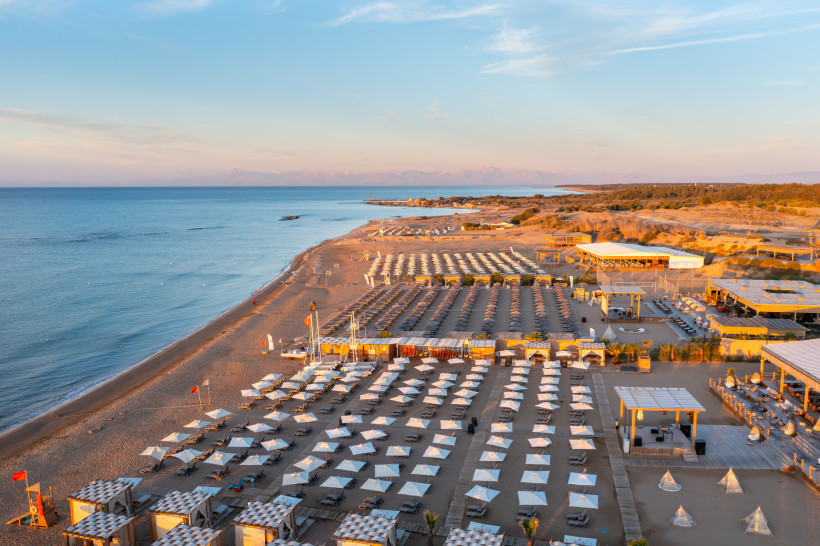 Breiter Sandstrand von Gündoğdu bei Side mit Sonnenliegen, Strandbars und ruhigem Meer