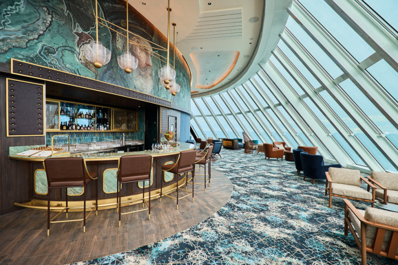Mein Schiff Relax – Captain's Bar mit Barbereich und Lounge vor der Panoramafensterfront Captain's Bar an Bord der Mein Schiff Relax mit geschwungener Theke, Barhockern und Sitzbereich vor großer Fensterfront