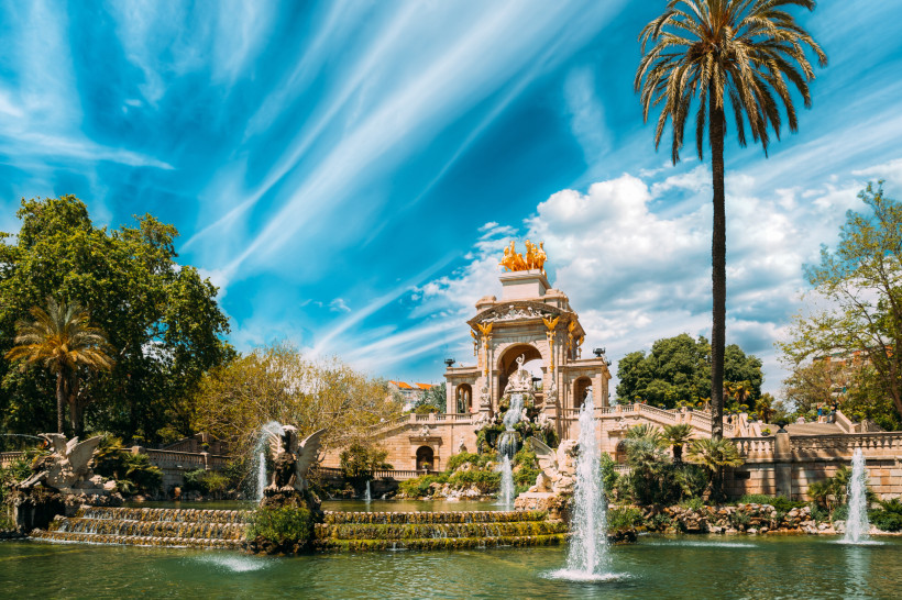 Cascada Monumental, Parc de la Ciutadella, Barcelona Brunnen Cascada Monumental im Parc de la Ciutadella in Barcelona mit Wasserfontänen, Palmen und blauem Himmel