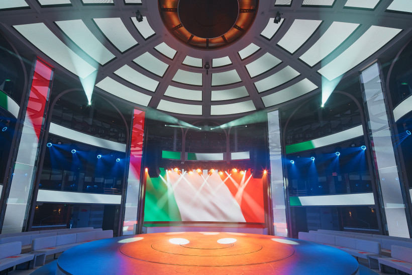 Veranstaltungsraum mit runder Bühne und LED-Wand in Grün, Weiß und Rot Innenraum eines Veranstaltungsraums mit runder Bühne, Kuppeldecke und LED-Wand in den Farben der italienischen Flagge
