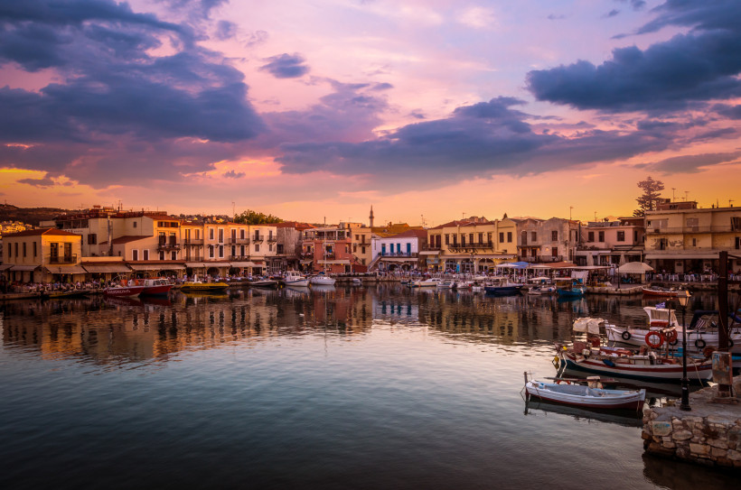 Hafen von Rethymno bei Sonnenuntergang mit Booten und Uferbebauung