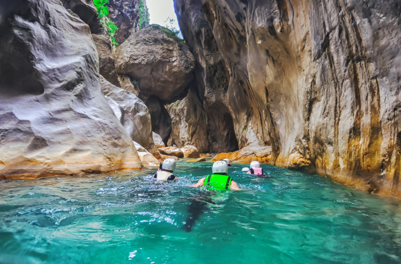 Outdoor-Abenteuer in Belek – Naturerlebnisse und Canyoning im beeindruckenden Gebirge Gruppe von Aktivurlaubern beim Schwimmen durch einen türkisfarbenen Canyon nahe Belek – perfektes Naturerlebnis für Abenteurer und Outdoor-Fans