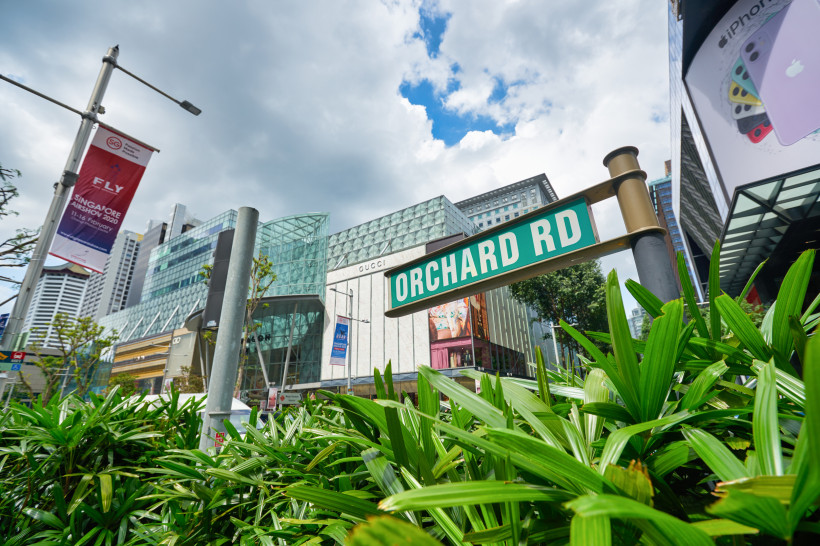 Orchard Road Einkaufsstraße in Singapur Straßenschild Orchard Road vor modernen Einkaufszentren in Singapur mit Gucci-Store und Wolkenkratzern im Hintergrund