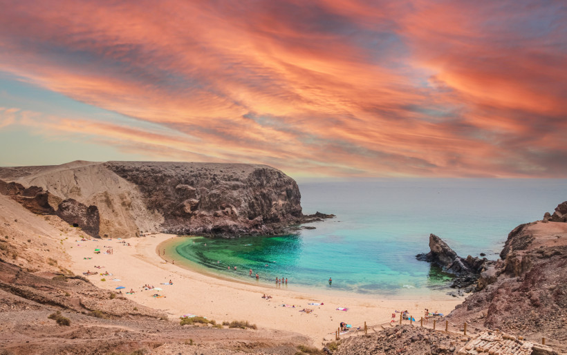Playa Papagayo Lanzarote – Traumhafte Bucht im Sonnenuntergang Panoramablick auf die Playa Papagayo auf Lanzarote bei farbenprächtigem Sonnenuntergang, mit türkisblauem Wasser und geschützter Sandbucht.