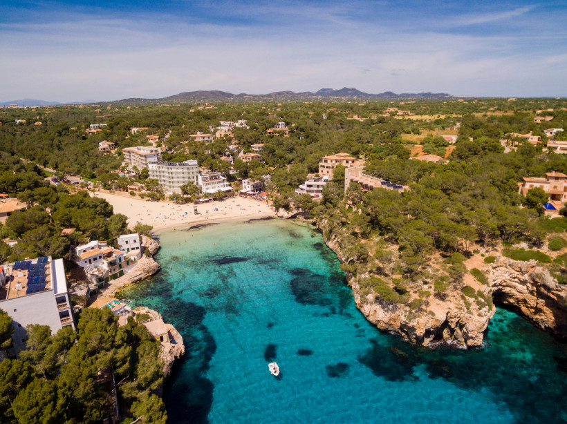 Cala Santanyí – Traumhafte Badebucht im Südosten Mallorcas Cala Santanyí Mallorca Luftaufnahme mit türkisblauem Meer, Sandstrand, Felsen und Pinienwald