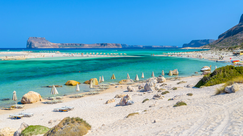 Balos-Lagune und Insel Gramvousa auf Kreta Balos-Lagune mit türkisfarbenem Wasser, hellem Sandstrand und Sonnenschirmen, im Hintergrund die Insel Gramvousa