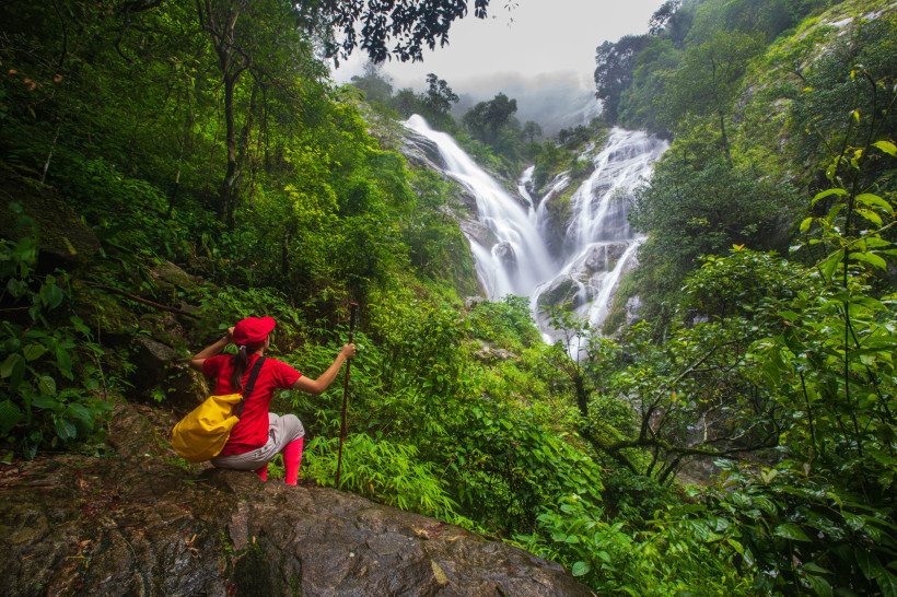 Thailand Aktivurlaub – Wanderung zum Mae-Ya-Wasserfall im Dschungel von Chiang Mai Wanderer im Dschungel von Chiang Mai mit Blick auf den beeindruckenden Mae-Ya-Wasserfall – Aktivurlaub in Thailand