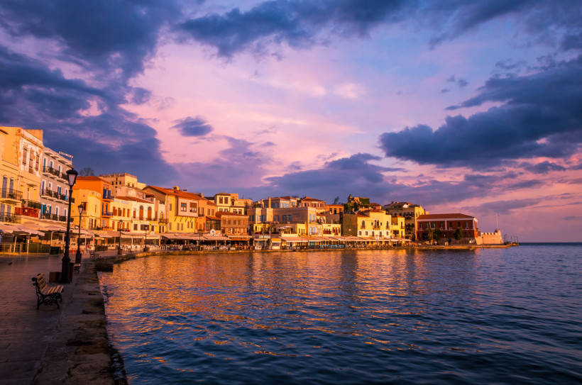 Uferpromenade mit Cafés und Häusern am Wasser bei Sonnenuntergang