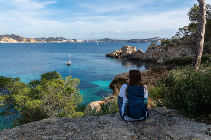 Blick auf die Küste bei Cala Fornells nahe Santa Ponsa auf Mallorca mit Wanderer und türkisblauem Meer