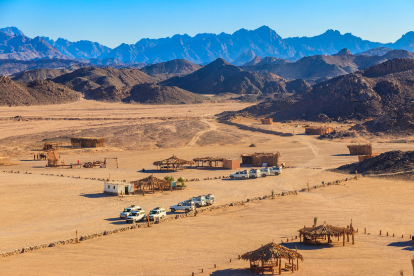 Wüstencamp mit einfachen Hütten und Jeeps in der Berglandschaft bei Hurghada