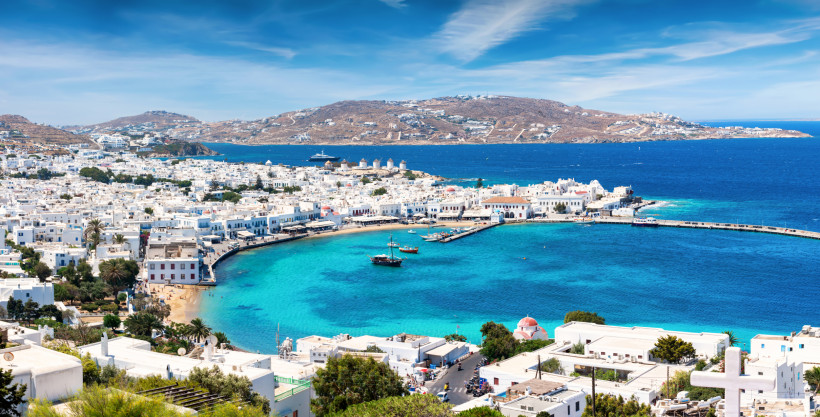 Blick auf die Bucht von Mykonos mit weißer Altstadt, Hafen und türkisblauem Meer im östlichen Mittelmeer