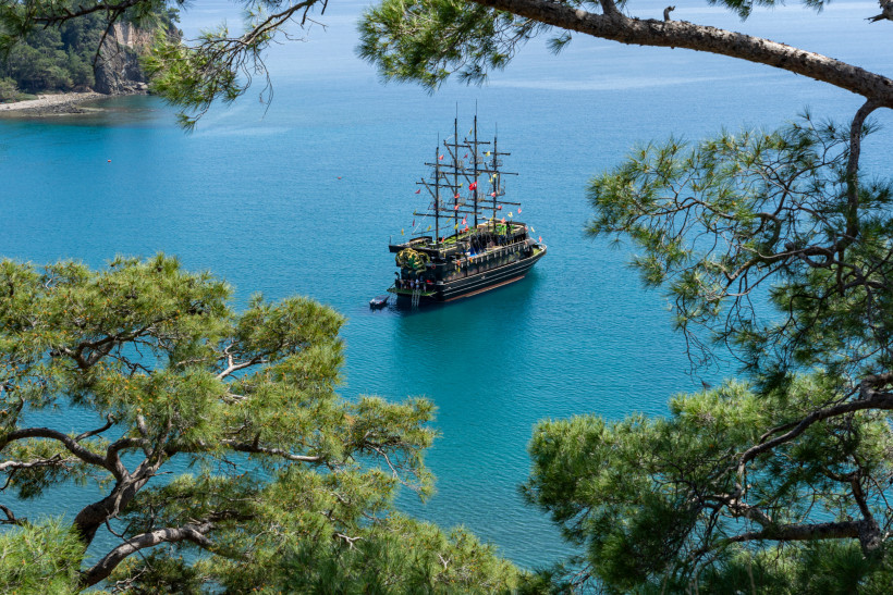 Ausflugsboot in einer ruhigen Bucht bei Kemer mit klarem Meer und grüner Küste