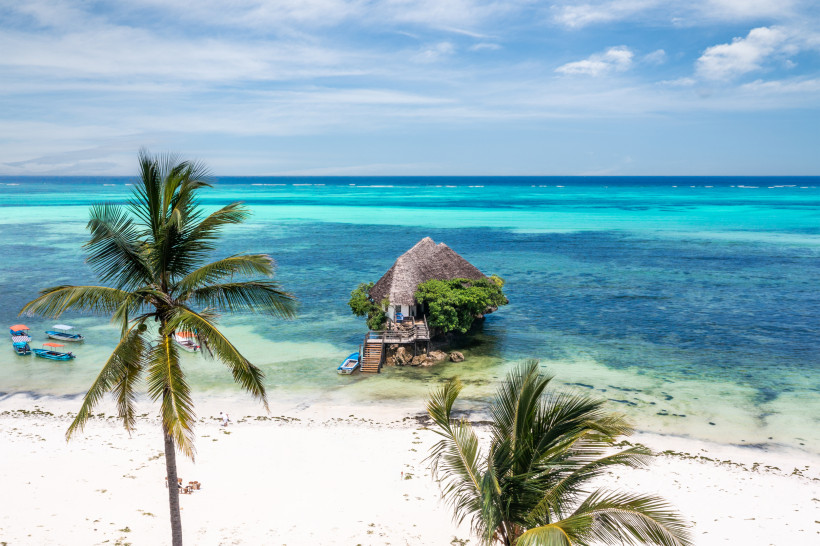 Sansibar -  The Rock Restaurant Das bekannte Restaurant The Rock auf Sansibar, idyllisch auf einem Felsen im türkisblauen Meer gelegen, mit Sandstrand und Palmen im Vordergrund