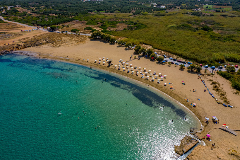 Luftaufnahme von Potamos Beach mit Sandstrand, türkisfarbenem Meer und Sonnenschirmen