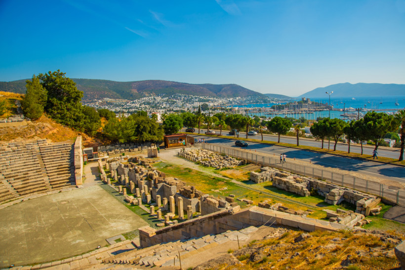 Archäologische Ruinen in Bodrum mit freigelegten Steinstrukturen, Straße und Blick auf Stadt, Yachthafen und Küste