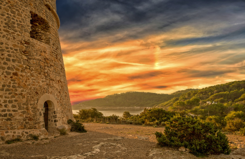 Steinerner Rundturm an der Küste bei Playa d'en Bossa im Abendlicht