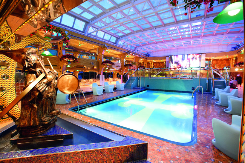 Costa Pacifica – Lido Calypso: Innenpool mit Glasdach und Sitzbereichen Innenpoolbereich Lido Calypso auf der Costa Pacifica mit Glasdach, Liegesitzen und Skulptur am Beckenrand