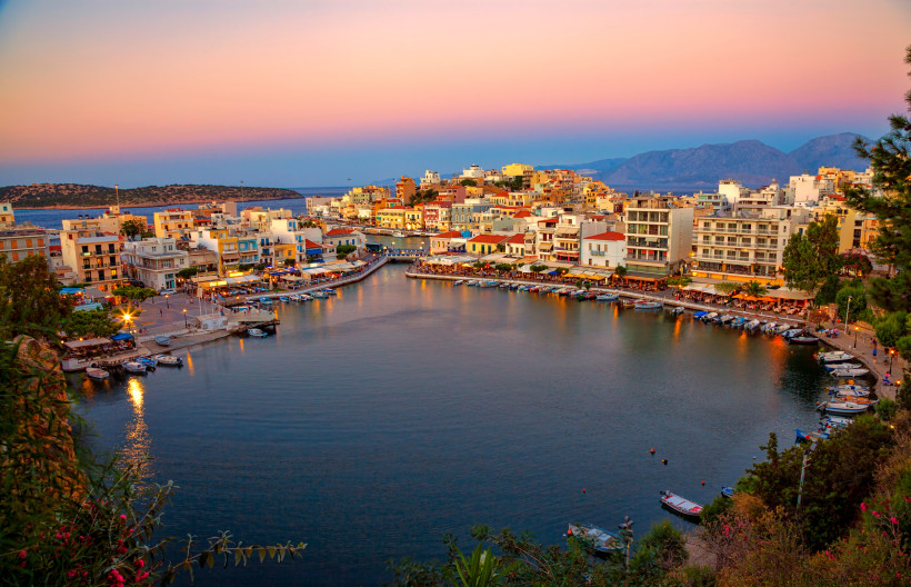 Voulismeni-See in Agios Nikolaos mit Hafen, Booten und Uferbebauung bei Abenddämmerung