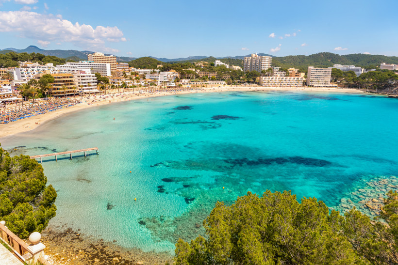 Bucht an der Playa Palmira mit Sandstrand, türkisblauem Wasser und Hotels entlang der Promenade